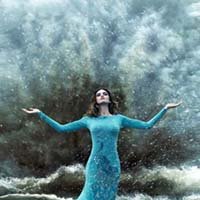 Une femme séduisante et élégante dans une tempête de sable et d'eau