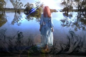 Femme avançant dans l'eau d'un lac avec des reflets d'arbres à l'horizon, et un ciel lumineux.